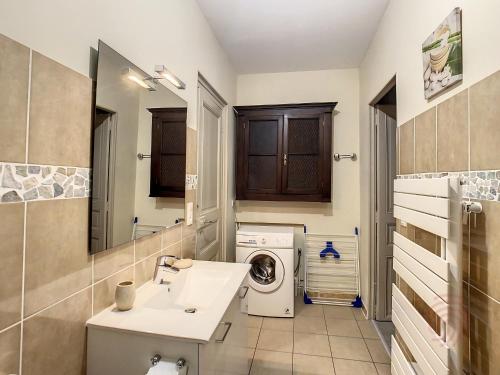 une salle de bain avec une machine à laver et un lavabo dans l'établissement Appartement F3 avec Wifi et Parking proche Thermes, animaux acceptés à Lamalou-les-Bains - FR-1-451-122, à Lamalou-les-Bains