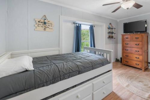 um quarto com uma cama, uma televisão e uma cómoda em Grandbay Oasis em Grand Bay