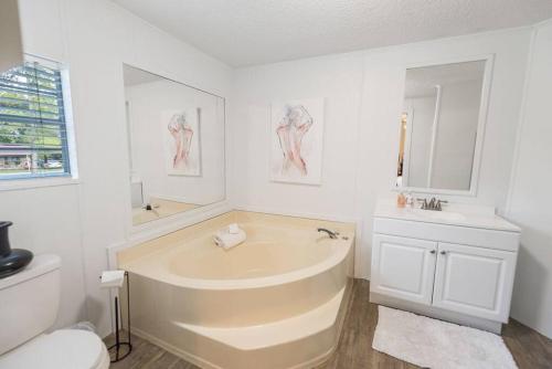 ein weißes Badezimmer mit einer Badewanne und einem Waschbecken in der Unterkunft Grandbay Oasis in Grand Bay
