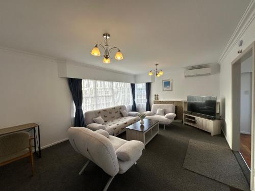 a living room with two couches and a television at Gracious 3 Bdrm House in Chartwell in Hamilton