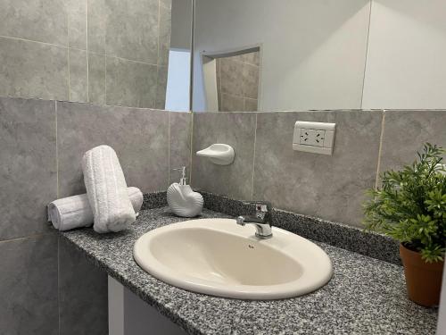 a bathroom counter with a sink and a mirror at Mar y Rio Duplex in Playa Unión