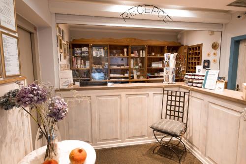 a shop with a counter and a chair and a table at Hotel Maxant in Frymburk