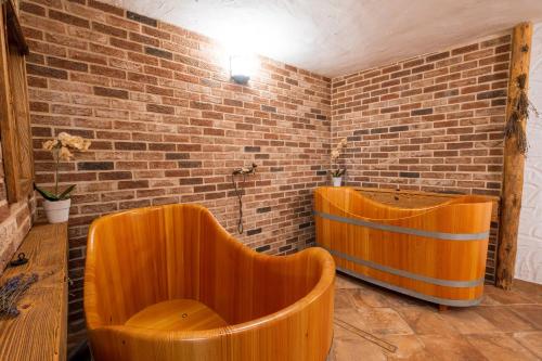 two wooden tubs in a room with a brick wall at Hotel Maxant in Frymburk