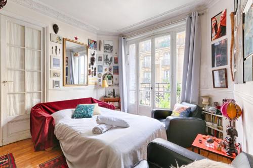 1 dormitorio con 1 cama en una habitación con ventanas en Résidor - Apartment in the heart of Montmartre, en París