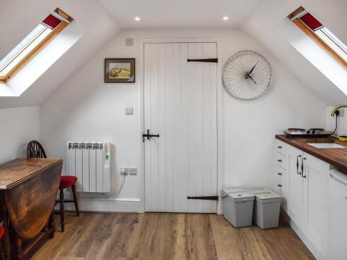 a kitchen with a white door and a wheel on the wall at Old Chimneys Studio in Lewes