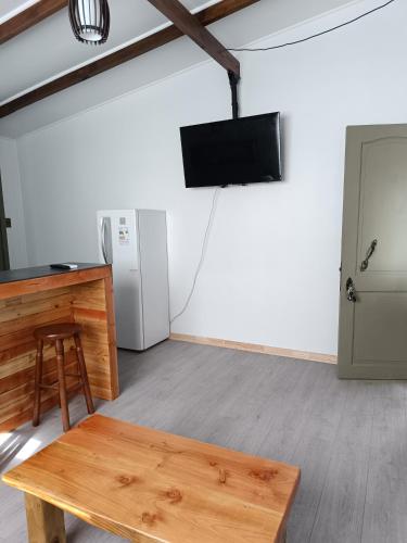 a room with a table and a television and a refrigerator at Punto clave 3 in Ancud