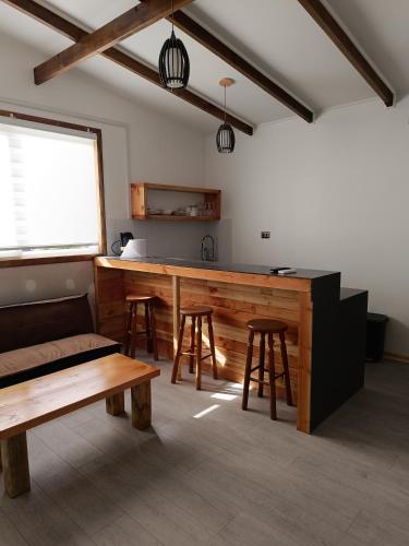 Habitación con bar con taburetes y mesa en Punto clave 3, en Ancud