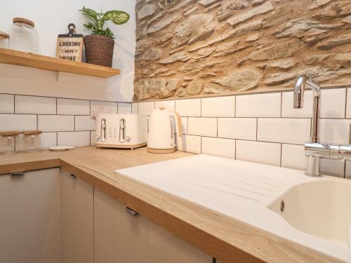 una cocina con fregadero y encimera en The Wonky Burrow, en Bowness-on-Windermere