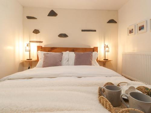 Un dormitorio con una gran cama blanca con dos lámparas. en The Wonky Burrow, en Bowness-on-Windermere