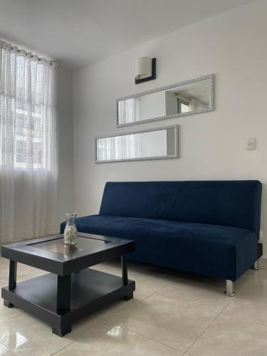 a blue couch in a living room with a coffee table at Alojamiento Ricaurte Piso 6 in Ricaurte