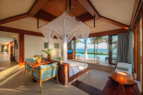 a bedroom in a villa with a bed and a desk at Fusion Resort Cam Ranh - All Spa Inclusive in Cam Ranh