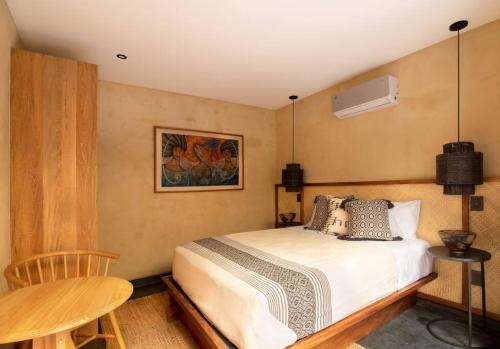 a bedroom with a bed and a table and a fan at Casa Rufina Oaxaca Centro - Adults Only in Oaxaca City