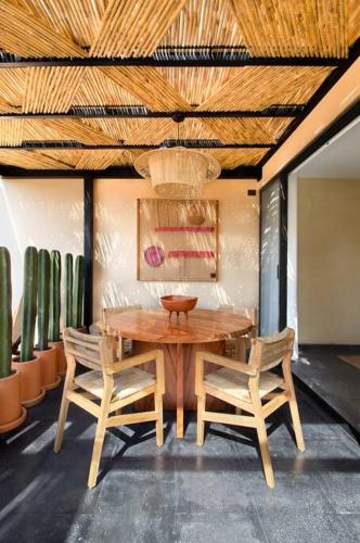 a wooden table and chairs in a room with cactus at Casa Rufina Oaxaca Centro - Adults Only in Oaxaca City