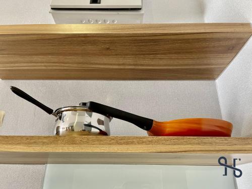 a wooden shelf with a pot and a spoon on it at Homesuite' Home at Aeropod SOVO in Kota Kinabalu