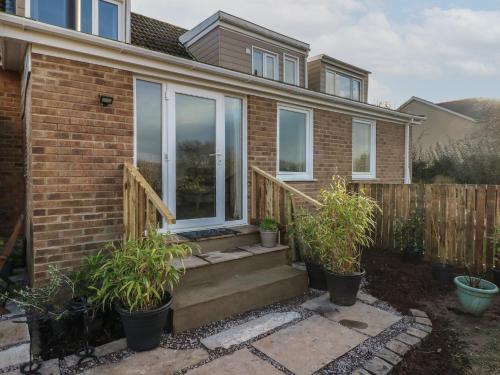 a home with windows and potted plants on the stairs at Garden View in Pembroke