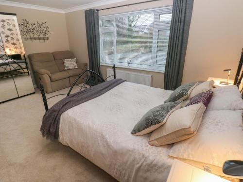 a bedroom with a bed and a chair and a window at Garden View in Pembroke