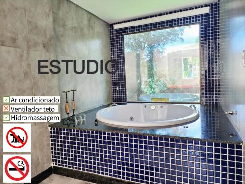 a bath tub in a bathroom with a window at Pousada do Rodrigo in Macacos
