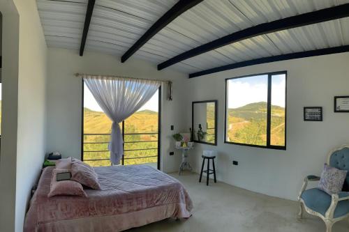 um quarto com uma cama e uma grande janela em Casa de Campo Natural y Tranquila 
