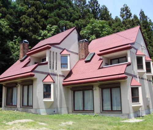 een huis met een rood dak bij Cottage Hotel Fenice Hakuba in Hakuba