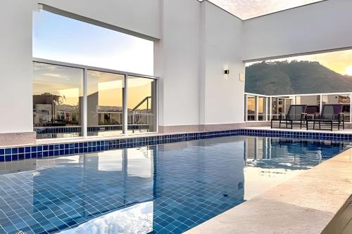 a swimming pool with blue tiles in a house at Nosso Apê 915: Central | Academia | Piscina NA0714 in Juiz de Fora