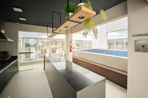 a kitchen with a swimming pool in a house at Nosso Apê 915: Central | Academia | Piscina NA0714 in Juiz de Fora
