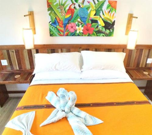 Una cama con una toalla encima. en The Tiki Toucan Tropical Suite + Private Pool, en Placencia Village