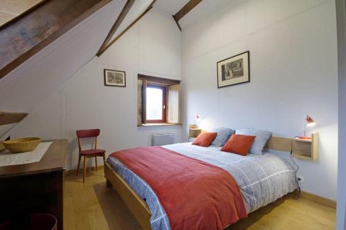 een slaapkamer met een bed, een bureau en een raam bij La grange du manoir de kermain in Langonnet