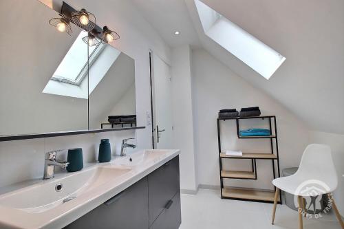 un bagno bianco con lavandino e specchio di Le colombier a Dinan