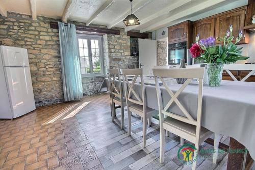 une cuisine avec une table avec des chaises et un réfrigérateur dans l'établissement 2 route de l'huitre, à Locoal-Mendon