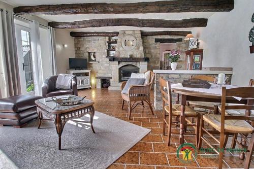 un salon avec une table et une cheminée dans l'établissement De la quenouille, à Locoal-Mendon