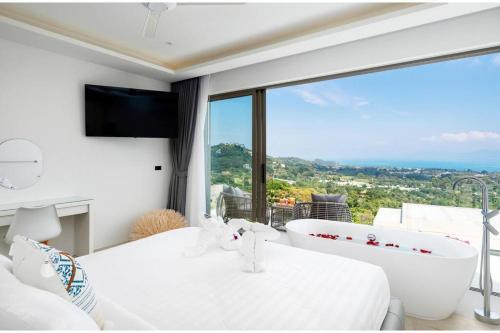 una camera da letto con vasca e ampia finestra di Luxury 5 Bedroom Modern Villa! KBR17 a Nathon Bay