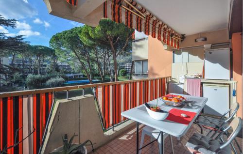 een balkon met een tafel en uitzicht op de straat bij Cozy Apartment In Mandelieu-la-napoule With Outdoor Swimming Pool in Mandelieu-la-Napoule
