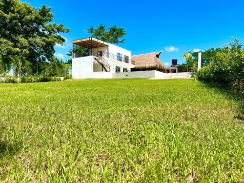 a house with a grassy field in front of it at CASA CAMPESTRE A POCOS MINUTOS DE CARTAGENA in Santa Rosa