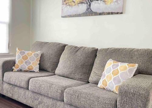 a couch with pillows on it in a living room at Lady Madonna Citra Flat in Salt Lake City