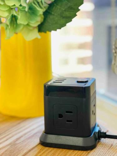 a black router sitting on a table next to a vase at Lady Madonna Citra Flat in Salt Lake City