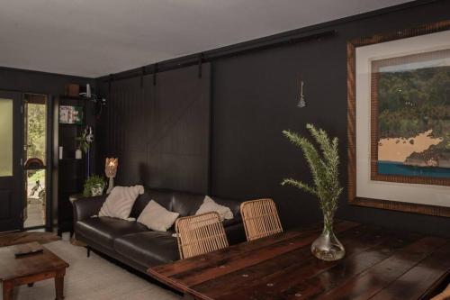 a living room with a couch and a table at Dark Moon House in Yandina Creek