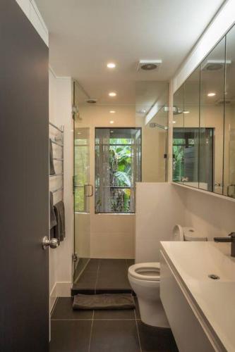 a bathroom with a toilet and a sink and a shower at Dark Moon House in Yandina Creek