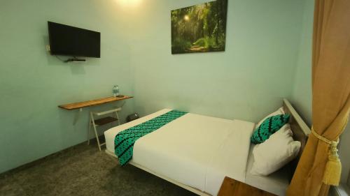 BrumbungにあるKalimaya Residence Syariah 1 by Cocotelの小さなベッドルーム(ベッド1台、テレビ付)