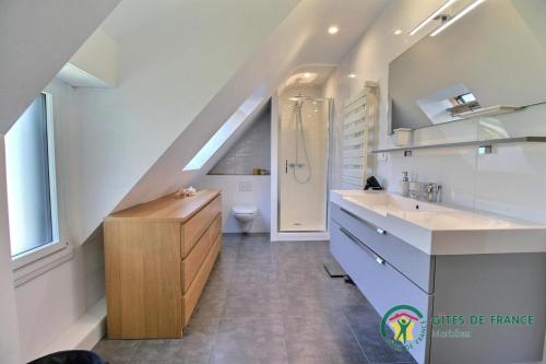 La salle de bains est pourvue d'un lavabo et de toilettes. dans l'établissement Villa mimosas, à Brech