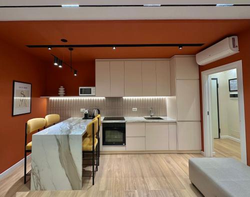 eine Küche mit weißen Schränken und einer orangefarbenen Wand in der Unterkunft Luxurious Dreamy seaside apartment in Durrës