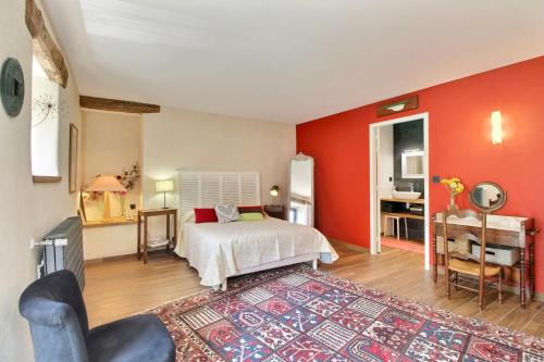 een slaapkamer met rode muren, een bed en een bureau bij Le val de kerderff in Le Bono