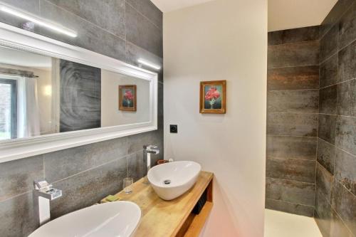 een badkamer met 2 wastafels en een spiegel bij Le val de kerderff in Le Bono