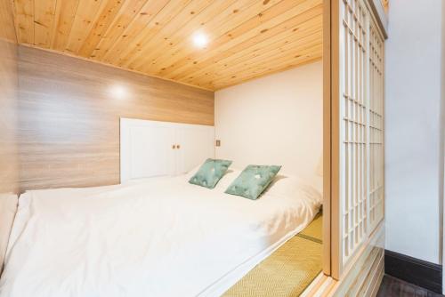 a bedroom with a large white bed with wooden ceilings at Shanghai Hills & Xing 38 Homestay in Shanghai