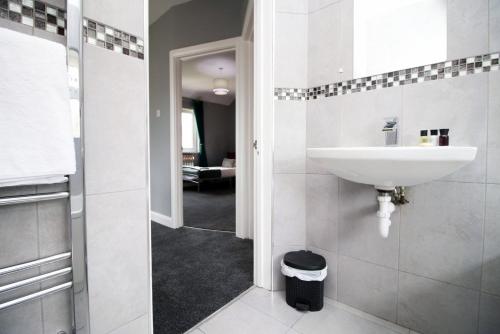 Baño blanco con lavabo y pasillo en Spacious | 3BR | WiFi en Newport