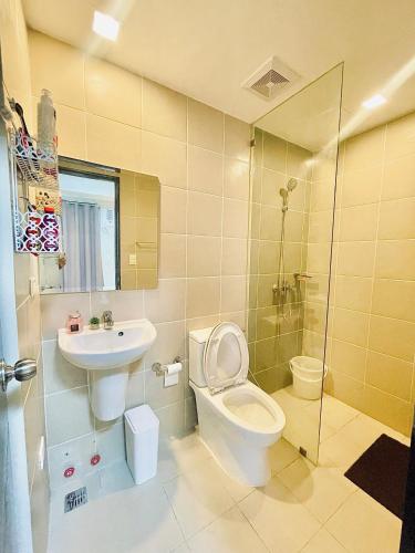 a bathroom with a toilet and a sink and a shower at Eli's sunset crib - The Palladium in Iloilo City