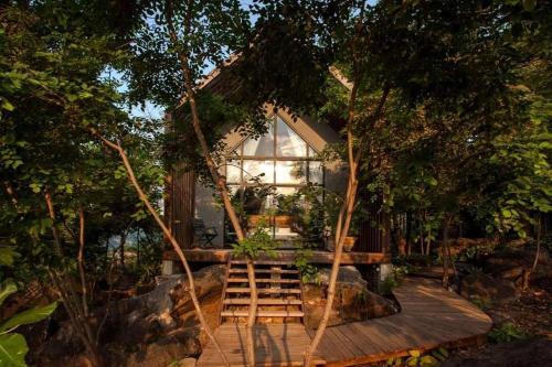 una pequeña casa con una escalera de madera que conduce a ella en Kampot Trip, 
