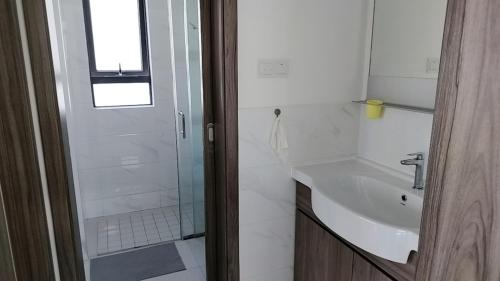 a white bathroom with a shower and a sink at ForesrCity私房雨露16 in Kampong Pok Kechil