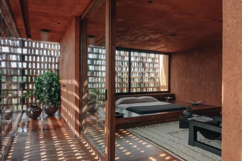 een slaapkamer met een bed en grote ramen bij Further Hotel in Canggu