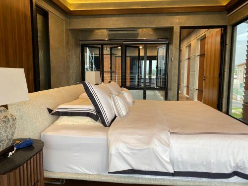 a large white bed in a room with a window at Villa AZJA PD in Port Dickson
