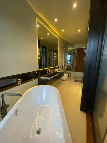 a bathroom with a tub and a large mirror at Villa AZJA PD in Port Dickson